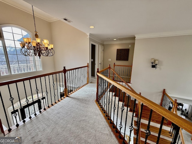 hall with carpet, crown molding, and an inviting chandelier