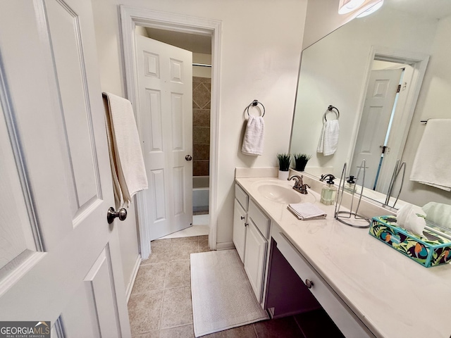 bathroom featuring tiled shower / bath, tile patterned floors, and vanity