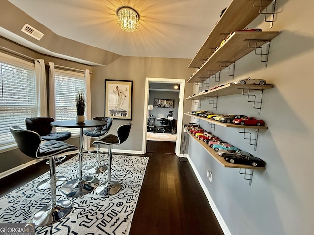 living area with dark wood-type flooring and an inviting chandelier