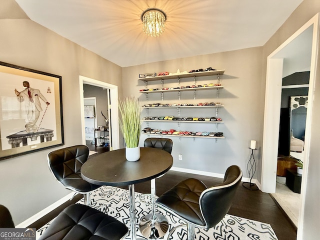 dining space with hardwood / wood-style floors and a notable chandelier