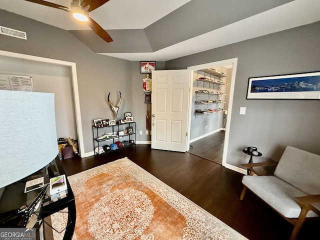 living area featuring ceiling fan and dark hardwood / wood-style flooring