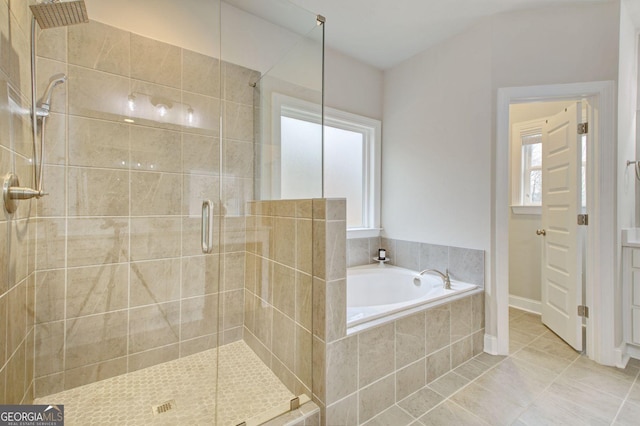 bathroom with a wealth of natural light, independent shower and bath, and tile patterned flooring