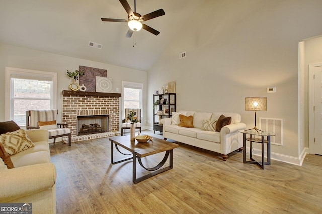 living room with ceiling fan, plenty of natural light, light hardwood / wood-style flooring, and a fireplace