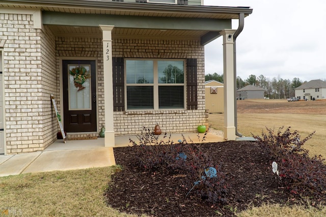 view of exterior entry featuring covered porch