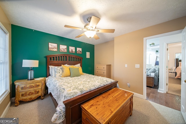 carpeted bedroom with ceiling fan and a textured ceiling