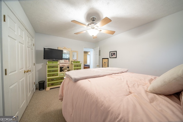 carpeted bedroom featuring a textured ceiling, ceiling fan, and a closet