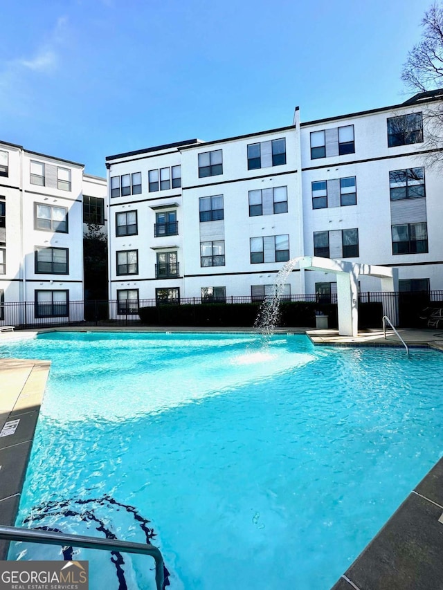 view of swimming pool with pool water feature