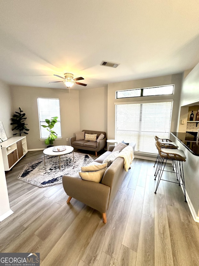 living room featuring ceiling fan and light hardwood / wood-style flooring