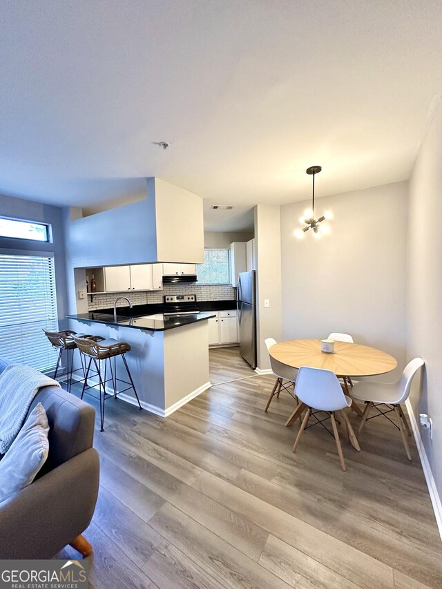 kitchen featuring light hardwood / wood-style floors, white cabinetry, appliances with stainless steel finishes, and track lighting