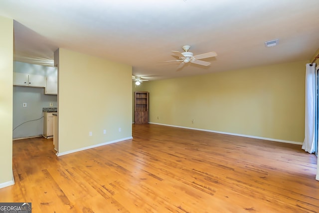 unfurnished living room featuring ceiling fan and light hardwood / wood-style flooring