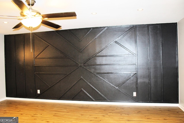 empty room with ceiling fan and hardwood / wood-style floors