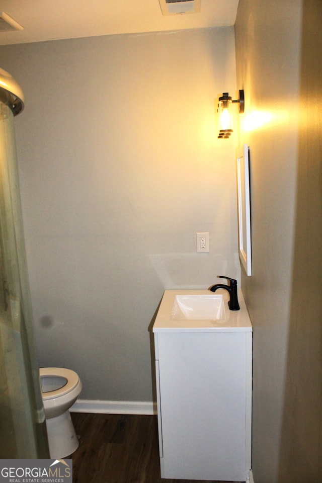 bathroom featuring toilet, vanity, and hardwood / wood-style flooring