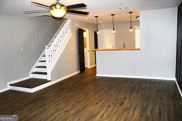 unfurnished living room with ceiling fan and dark hardwood / wood-style flooring