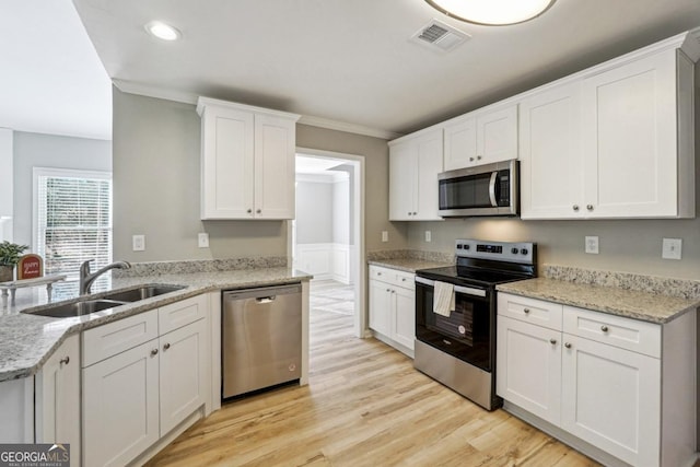 kitchen featuring light hardwood / wood-style floors, sink, stainless steel appliances, white cabinets, and light stone counters