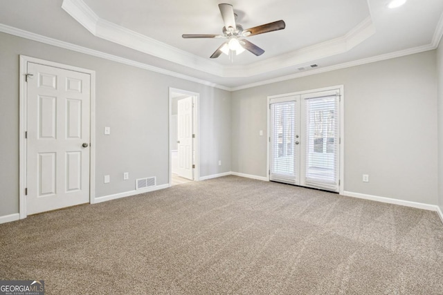 carpeted spare room featuring french doors, ceiling fan, crown molding, and a raised ceiling