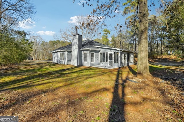 exterior space with a sunroom and a lawn