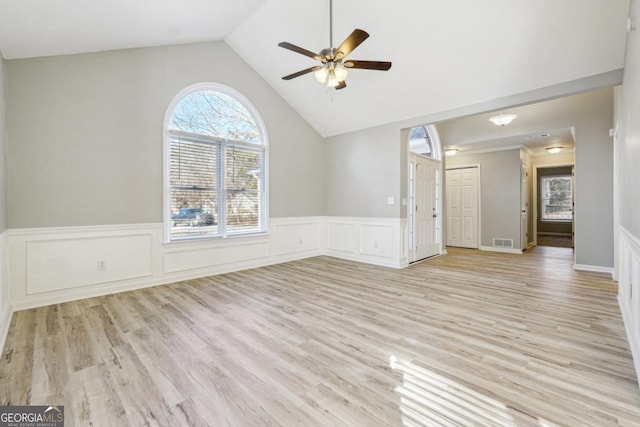 unfurnished living room featuring light wood-type flooring, vaulted ceiling, and ceiling fan