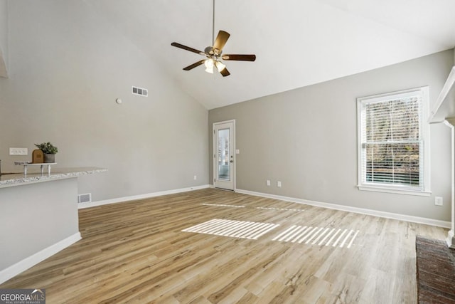 unfurnished living room with high vaulted ceiling, light hardwood / wood-style flooring, and ceiling fan