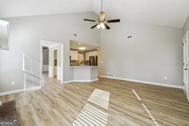 unfurnished living room with ceiling fan, high vaulted ceiling, and light hardwood / wood-style flooring