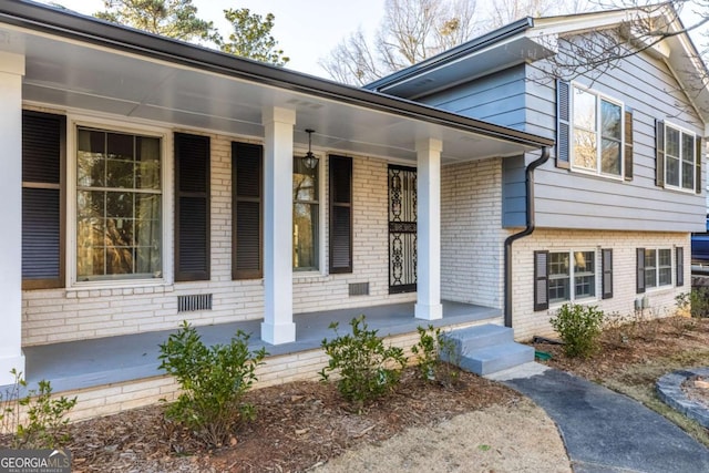 view of exterior entry featuring covered porch