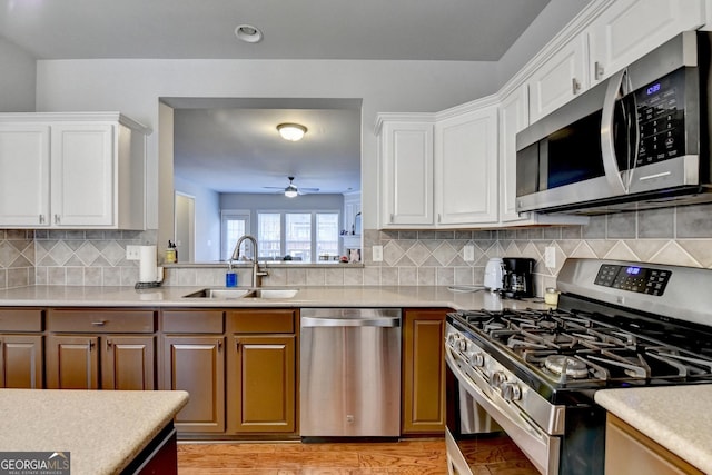 kitchen featuring white cabinetry, ceiling fan, stainless steel appliances, tasteful backsplash, and sink