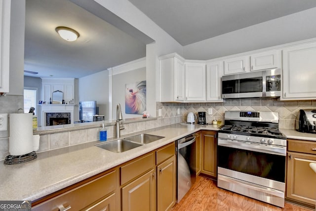 kitchen featuring backsplash, light hardwood / wood-style floors, sink, stainless steel appliances, and white cabinets