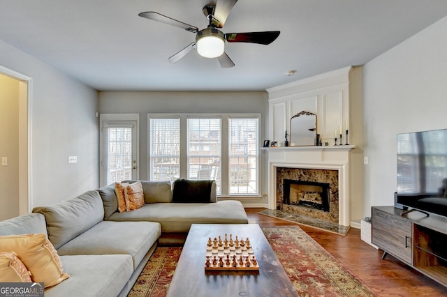 living room with ceiling fan, a fireplace, and hardwood / wood-style floors