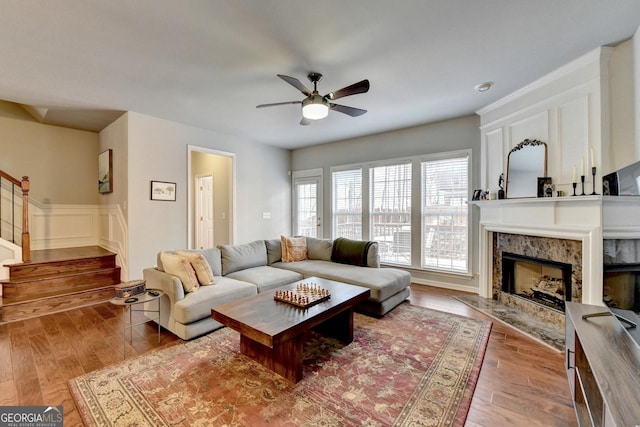 living room featuring ceiling fan, a fireplace, and hardwood / wood-style flooring