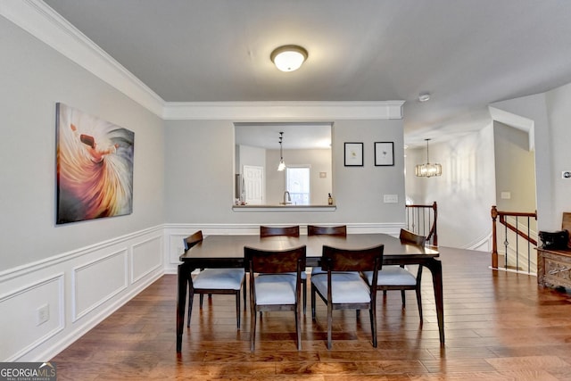 dining area with an inviting chandelier, ornamental molding, and hardwood / wood-style floors