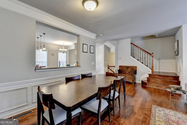 dining room featuring an inviting chandelier, ornamental molding, and hardwood / wood-style flooring