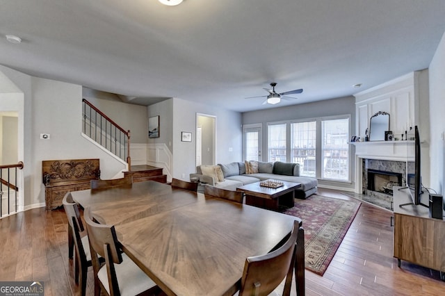 dining space featuring ceiling fan, a high end fireplace, and hardwood / wood-style floors