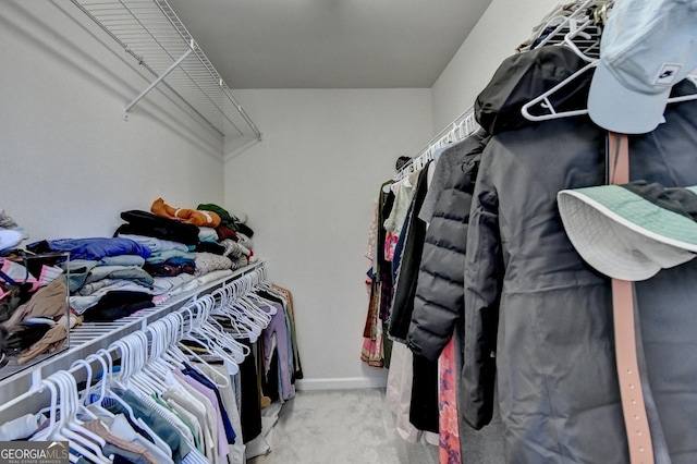 walk in closet featuring light colored carpet