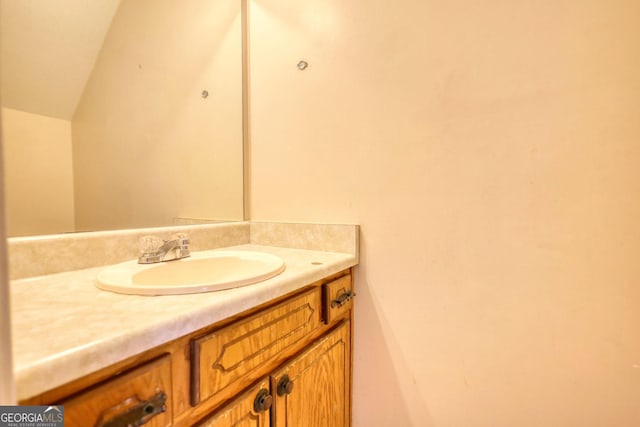 bathroom featuring vanity and lofted ceiling