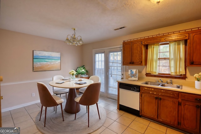 kitchen featuring dishwasher, sink, an inviting chandelier, hanging light fixtures, and light tile patterned floors