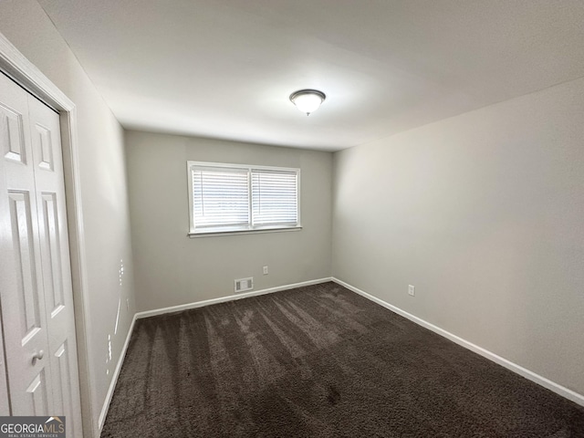 empty room with dark colored carpet