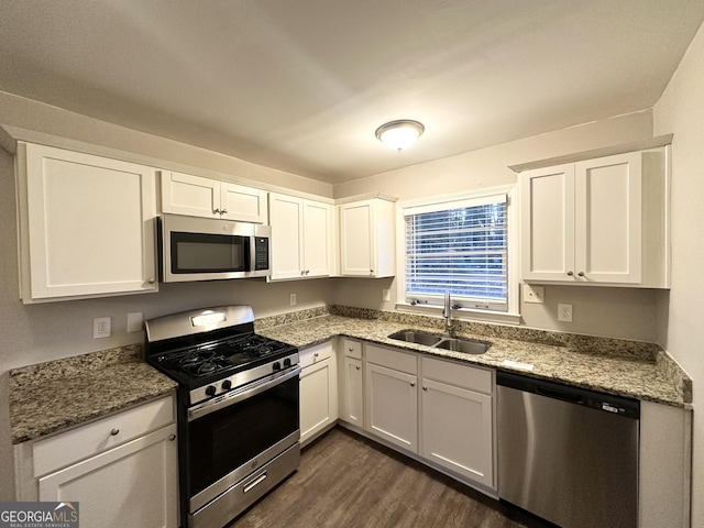 kitchen with stainless steel appliances, white cabinetry, and sink