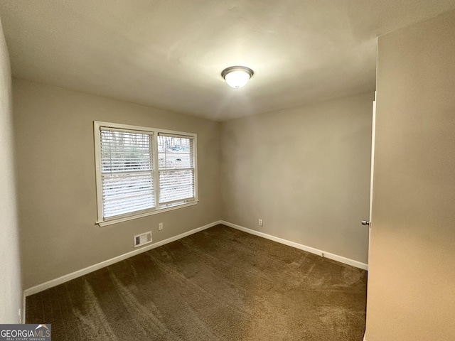 unfurnished room with dark carpet