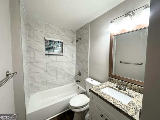 full bathroom featuring toilet, tiled shower / bath, and vanity