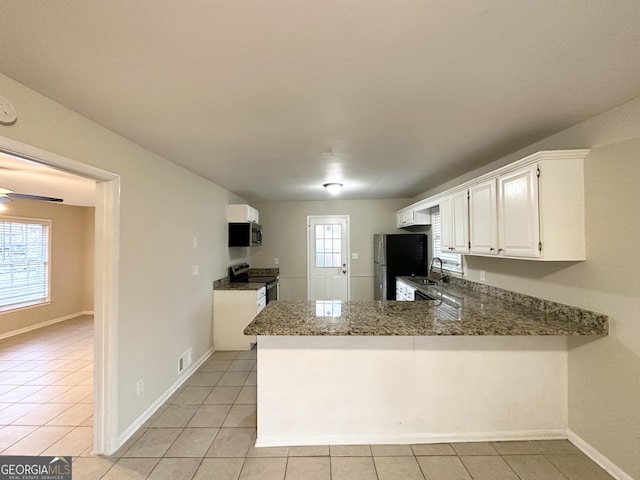 kitchen featuring kitchen peninsula, sink, a healthy amount of sunlight, appliances with stainless steel finishes, and white cabinets