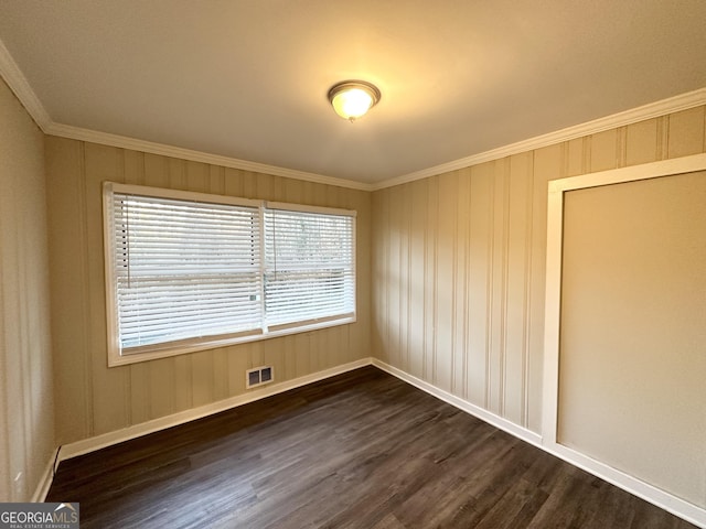 spare room with dark wood-type flooring and crown molding