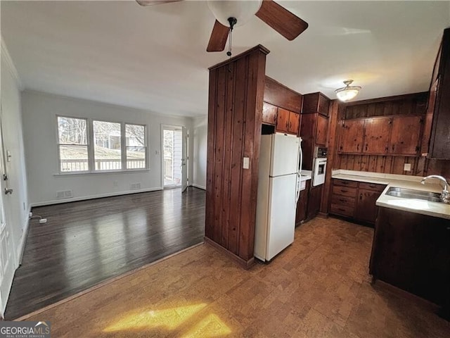 kitchen featuring ceiling fan, stainless steel oven, dark hardwood / wood-style flooring, white refrigerator, and sink