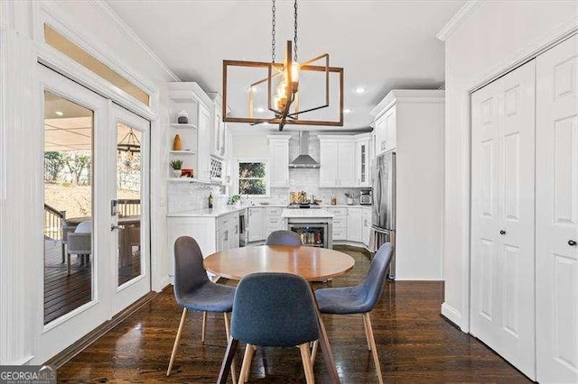 dining room with dark hardwood / wood-style flooring, a healthy amount of sunlight, and ornamental molding