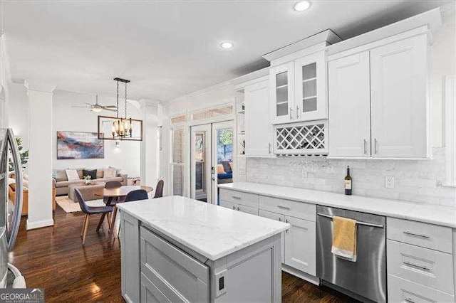 kitchen with stainless steel appliances, tasteful backsplash, a kitchen island, pendant lighting, and white cabinets