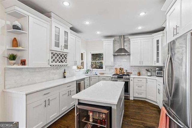 kitchen with wall chimney range hood, white cabinets, dark hardwood / wood-style floors, and stainless steel appliances