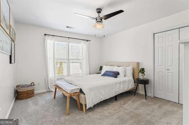 carpeted bedroom featuring ceiling fan and a closet