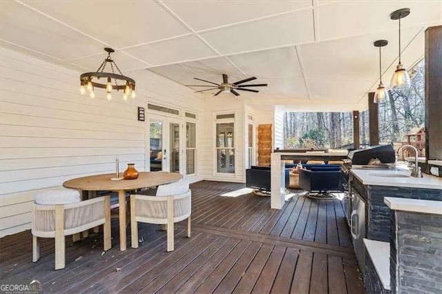 wooden deck with a wet bar and ceiling fan