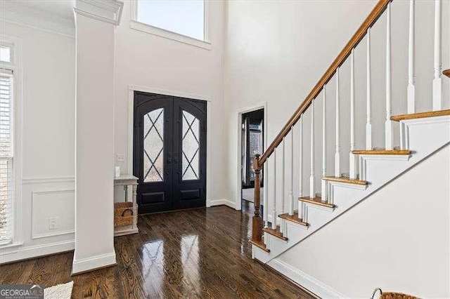 foyer with plenty of natural light, dark hardwood / wood-style flooring, and french doors