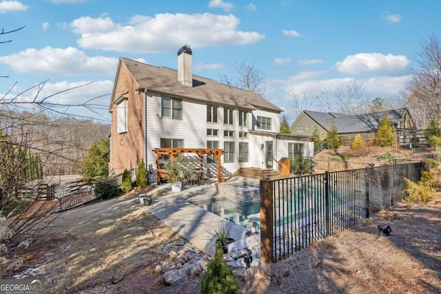 rear view of property with a fenced in pool