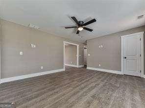 empty room featuring ceiling fan and dark hardwood / wood-style flooring