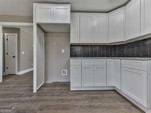 kitchen featuring dark wood-type flooring and white cabinetry